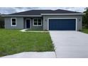 Charming single-story home with a well-maintained lawn and a two-car garage at 142 Guava Pass, Ocklawaha, FL 32179