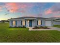Charming single-story home featuring a blue front door, blue shutters, and manicured front yard at 14698 Sw 20Th Pl, Ocala, FL 34481