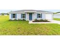 A single story home with a blue front door, blue shutters, a sidewalk, and newly planted landscaping at 14698 Sw 20Th Pl, Ocala, FL 34481