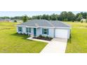 Attractive single-story home showcasing a manicured lawn, gray roof, and attached garage at 14893 Sw 23Rd Pl, Ocala, FL 34481