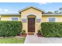 Inviting front entrance with a decorative door, potted plants, and neatly trimmed hedges at 16605 Sw 31 Cir, Ocala, FL 34473