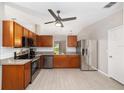 Modern kitchen with stainless steel appliances, wooden cabinets, and tile backsplash at 16605 Sw 31 Cir, Ocala, FL 34473