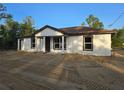 Charming single-story home with white exterior, brown trim, and a well-defined entrance at 20 Malauka Trail Crse, Ocklawaha, FL 32179