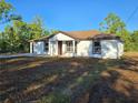 A welcoming one-story home featuring new construction, a brown roof, and a well manicured lawn at 20 Malauka Trail Crse, Ocklawaha, FL 32179