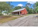 Charming home with a metal roof, covered porch, and long driveway, all nestled on a spacious lot at 23608 Ne 124 Place Rd, Salt Springs, FL 32134
