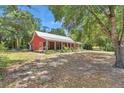 A charming home with a metal roof and a beautiful yard, nestled among mature trees and lush landscaping at 23608 Ne 124 Place Rd, Salt Springs, FL 32134