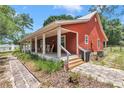 A cozy front porch featuring classic rocking chairs, framed by lush greenery and a welcoming entrance at 23608 Ne 124 Place Rd, Salt Springs, FL 32134