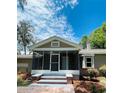 Close-up of the screened front porch with brick steps and accents and a front door at 4609 Ne 7Th St, Ocala, FL 34470