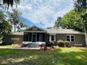 Charming single-story home with a screened porch, brick accents, and lush green lawn at 4609 Ne 7Th St, Ocala, FL 34470