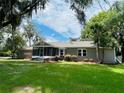 Inviting single-story home with screened porch, mature trees, and well-maintained lawn at 4609 Ne 7Th St, Ocala, FL 34470