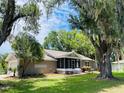 Charming single-story home with a screened porch and mature trees, creating a serene setting at 4609 Ne 7Th St, Ocala, FL 34470