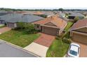 Aerial view of a home in a residential neighborhood featuring a brown roof with solar panels at 5587 Nw 40Th Pl, Ocala, FL 34482