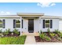 Home's entrance with manicured landscaping, black shutters, and inviting walkway at 6 Locust Loop Crse, Ocala, FL 34472