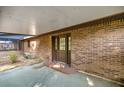 Covered patio featuring brick walls, a concrete floor, and a view into the screened porch and backyard at 6497 W Anthony Rd, Ocala, FL 34479