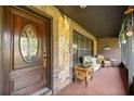 Inviting front porch showcasing a decorative front door, stone accents, and cozy seating area at 6497 W Anthony Rd, Ocala, FL 34479