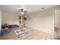 Spacious living room with a ceiling fan, wood-look floors, and natural light, complemented by neutral walls at 6497 W Anthony Rd, Ocala, FL 34479