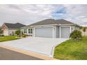 Attractive home with a spacious driveway, two-car garage, and manicured lawn at 6877 Minchew Cir, The Villages, FL 34762