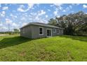 The backyard with its well-maintained lawn leads to a sliding glass door entry to the home at 75 Guava Ter, Ocklawaha, FL 32179