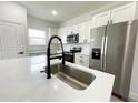 Bright kitchen featuring stainless steel appliances, quartz countertops, and a stylish island with a sink at 75 Guava Ter, Ocklawaha, FL 32179