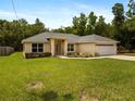 Charming single-story home with a well-manicured lawn, a two car garage and mature landscaping at 9432 Se 159Th Ln, Summerfield, FL 34491