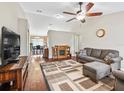 Cozy living room with hardwood floors, ceiling fan, fireplace, and comfortable seating at 11 Pecan Course Loop, Ocala, FL 34472
