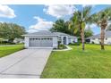 Charming single story home featuring well-maintained landscaping, blue paint, and a two car garage at 11051 Sw 73Rd Ct, Ocala, FL 34476