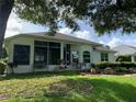 Spacious backyard featuring a covered patio, seating area, and lush landscaping at 11605 Sw 69Th Cir, Ocala, FL 34476