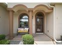 Charming front porch with decorative columns and a cozy bench, creating an inviting entrance at 12169 Se 172Nd Ln, Summerfield, FL 34491
