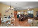 Spacious living area with hardwood floors seamlessly connecting to the open kitchen and dining space at 12169 Se 172Nd Ln, Summerfield, FL 34491