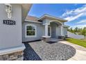 Beautiful exterior of a single-Gathering home with stone accents, a manicured gravel bed and a covered entry at 12392 Sw 85 Pl, Dunnellon, FL 34432