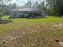 View of a spacious backyard with a screened-in porch and mature trees, offering a private outdoor space at 13155 Sw 73 Ave, Ocala, FL 34473