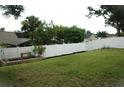 Spacious fenced backyard with green grass and garden area, perfect for outdoor activities at 14126 Greater Pines Blvd, Clermont, FL 34711