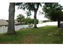 Lush backyard with tall trees and white fence, offering privacy and shade at 14126 Greater Pines Blvd, Clermont, FL 34711