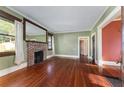 Spacious living room features hardwood floors, a brick fireplace, and ample natural light at 1434 Se Silver Springs Pl, Ocala, FL 34471