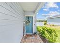 Inviting front porch with a blue door, a wreath, and a 'Hey Friends' sign, creating a warm welcome at 1814 Nw 44 Court Rd, Ocala, FL 34482