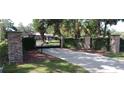 Elegant gated entrance with stone pillars and manicured greenery leading to the property at 3261 Se 41St Pl, Ocala, FL 34480