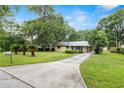 A charming single-story home with a metal roof, lush front lawn and a long driveway at 3621 Se 12Th Pl, Ocala, FL 34471