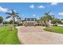 Beautiful brick home with a circular driveway, lion statues, and well-maintained landscaping at 4550 County Road 104, Oxford, FL 34484
