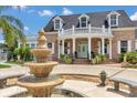 Beautiful brick home featuring a covered porch with columns and a fountain in the front yard at 4550 County Road 104, Oxford, FL 34484