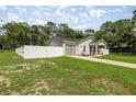 Single-story home featuring a garage, fenced yard, and well-kept lawn at 5063 Se 168Th Ter, Ocklawaha, FL 32179