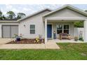 Cozy front porch with a rocking bench, welcome decor, and quaint landscaping at 5063 Se 168Th Ter, Ocklawaha, FL 32179