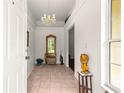 Welcoming foyer with chandelier, tiled floor, mirror, and statue offering a glimpse of the home's elegance at 5445 Ne Anthony Rd, Ocala, FL 34475
