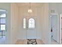 Inviting entryway with decorative front door, tiled floors and elegant lighting fixture at 5551 Nw 25Th Loop, Ocala, FL 34482