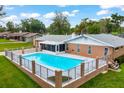 Outdoor in-ground swimming pool features a clear glass fence surround and patio area at 616 Se 40Th Ave, Ocala, FL 34471