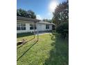 Well-kept backyard featuring a partial pergola, lush grass, and mature trees at 6241 Sw 84Th Pl, Ocala, FL 34476