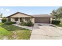 Well-kept single-story home featuring a manicured lawn, landscaped front yard, and concrete driveway at 6320 Se 42Nd Ct, Ocala, FL 34480