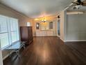 Open living room features wood-look floors and updated chandelier with built in storage at 741 Truman Ave, Lady Lake, FL 32159