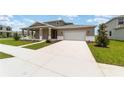 Inviting home with a large driveway leading to a two-car garage and a well-maintained front yard at 7745 Sw 56Th Pl, Ocala, FL 34474