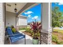 Inviting front porch with a comfortable bench and lush landscaping at 7891 Sw 89Th Cir, Ocala, FL 34481