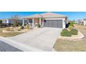 Beautiful single-story home with landscaped front yard, long driveway, covered porch with sitting area, and a two-car garage at 8878 Sw 103Rd Cir, Ocala, FL 34481